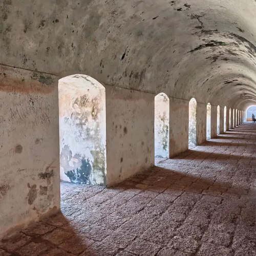 Sunlit archways along a 17th-century Dutch fort corridor