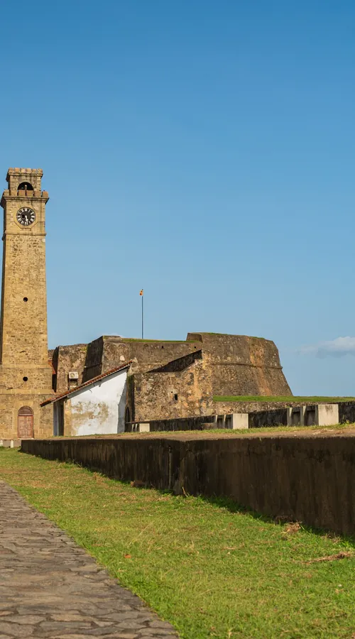 Galle's lighthouse and fort ramparts under a clear sky