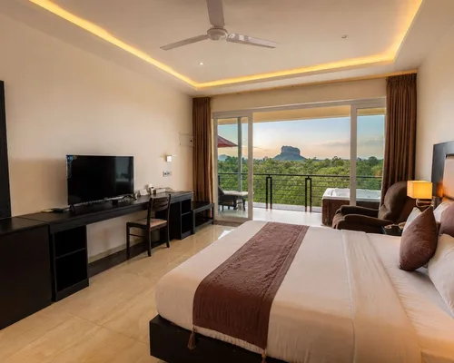 Bedroom at Cassandra Culture Resort with Sigiriya rock framed in the window at dawn